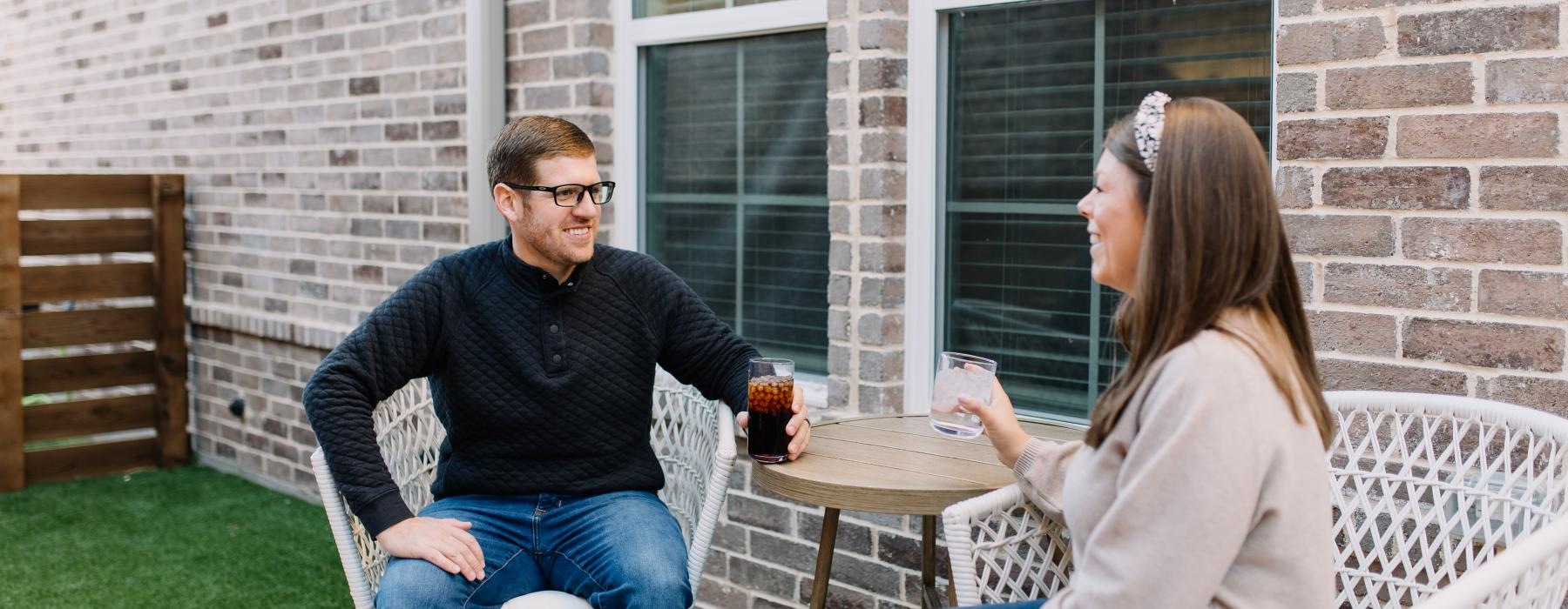 a man and woman sitting at a table outside