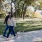 a man and woman walking a dog on a leash