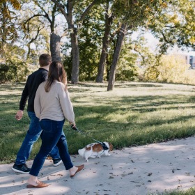 Trails and nature await a man and woman walking a dog on a leash